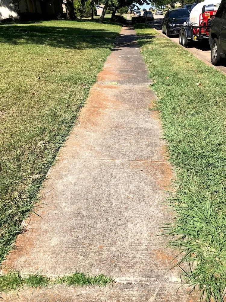 Residential concrete sidewalk with rust stains before cleaning
