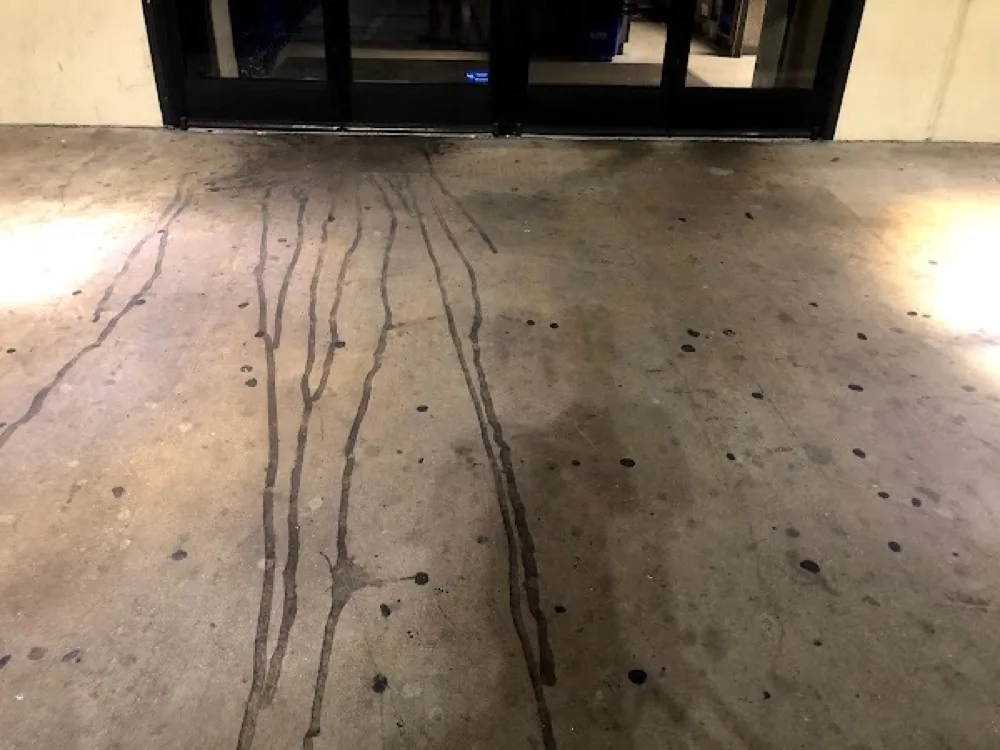 Storefront entrance concrete with dark stains before cleaning
