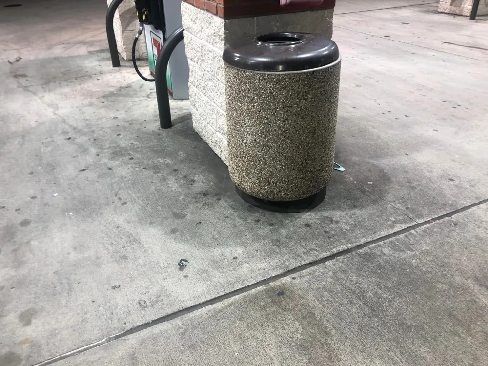 Convenience store trash area with stained concrete before cleaning